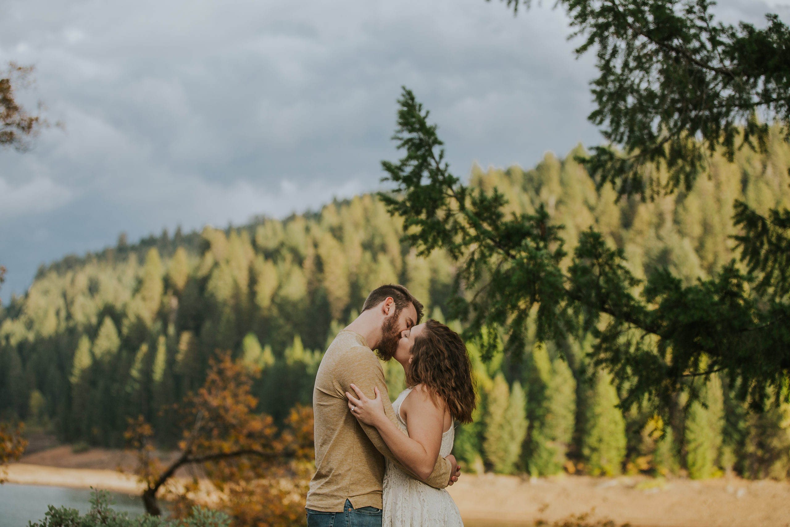 rebecca skidgel photography fall placerville engagement lake couple holding each other kissing