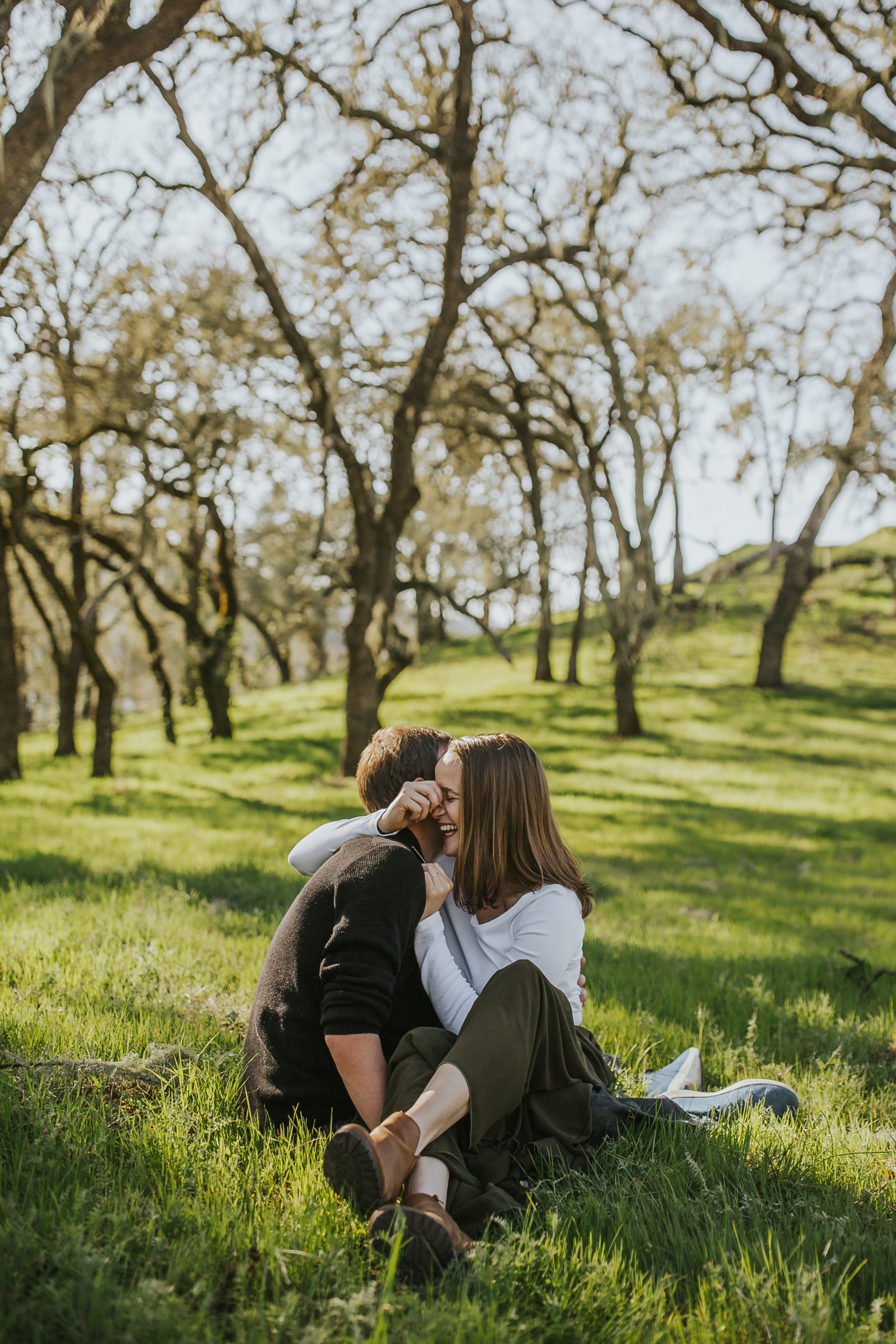 rebecca skidgel photography napa valley engagement photographer lake hennessey couple holding each other sitting laughing smiling