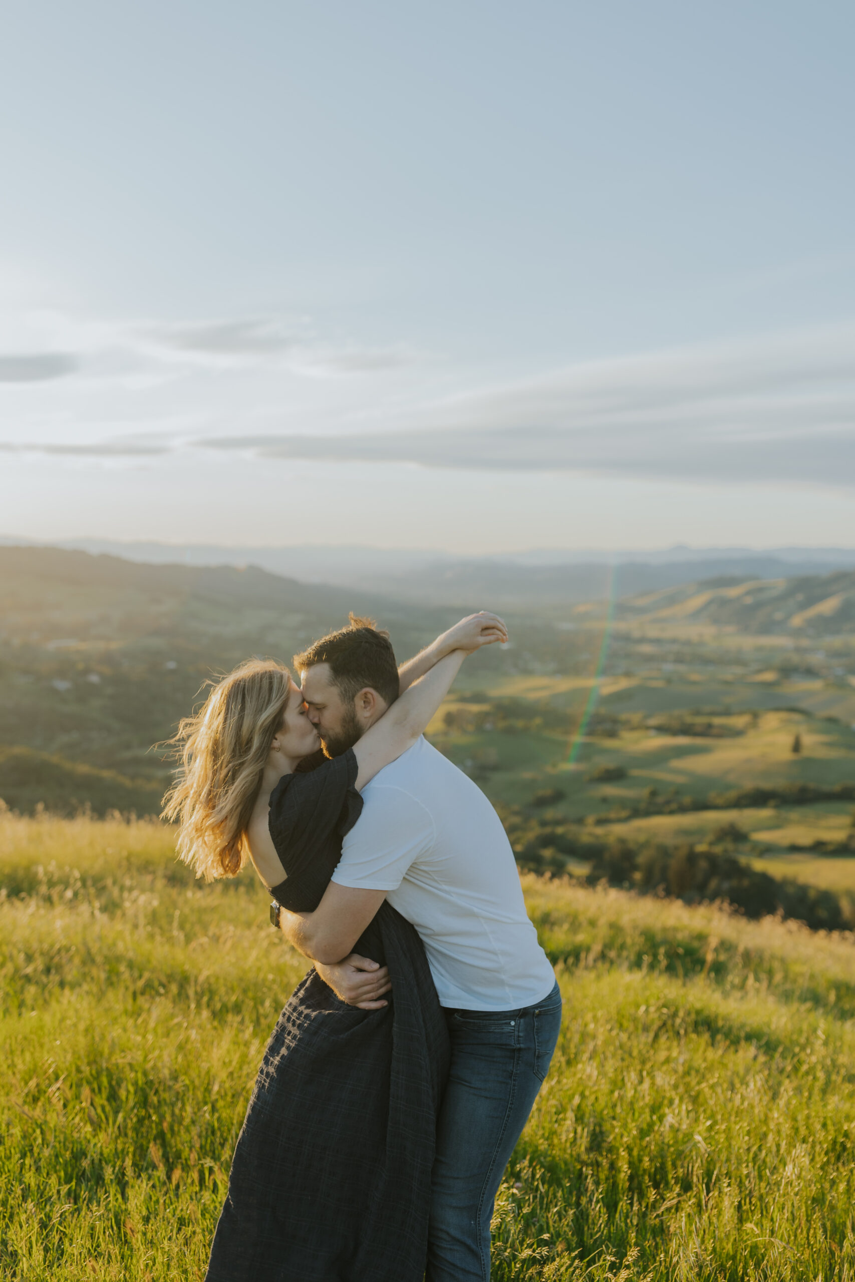 spring engagement session in sonoma county couple holding each other kissing at golden hour