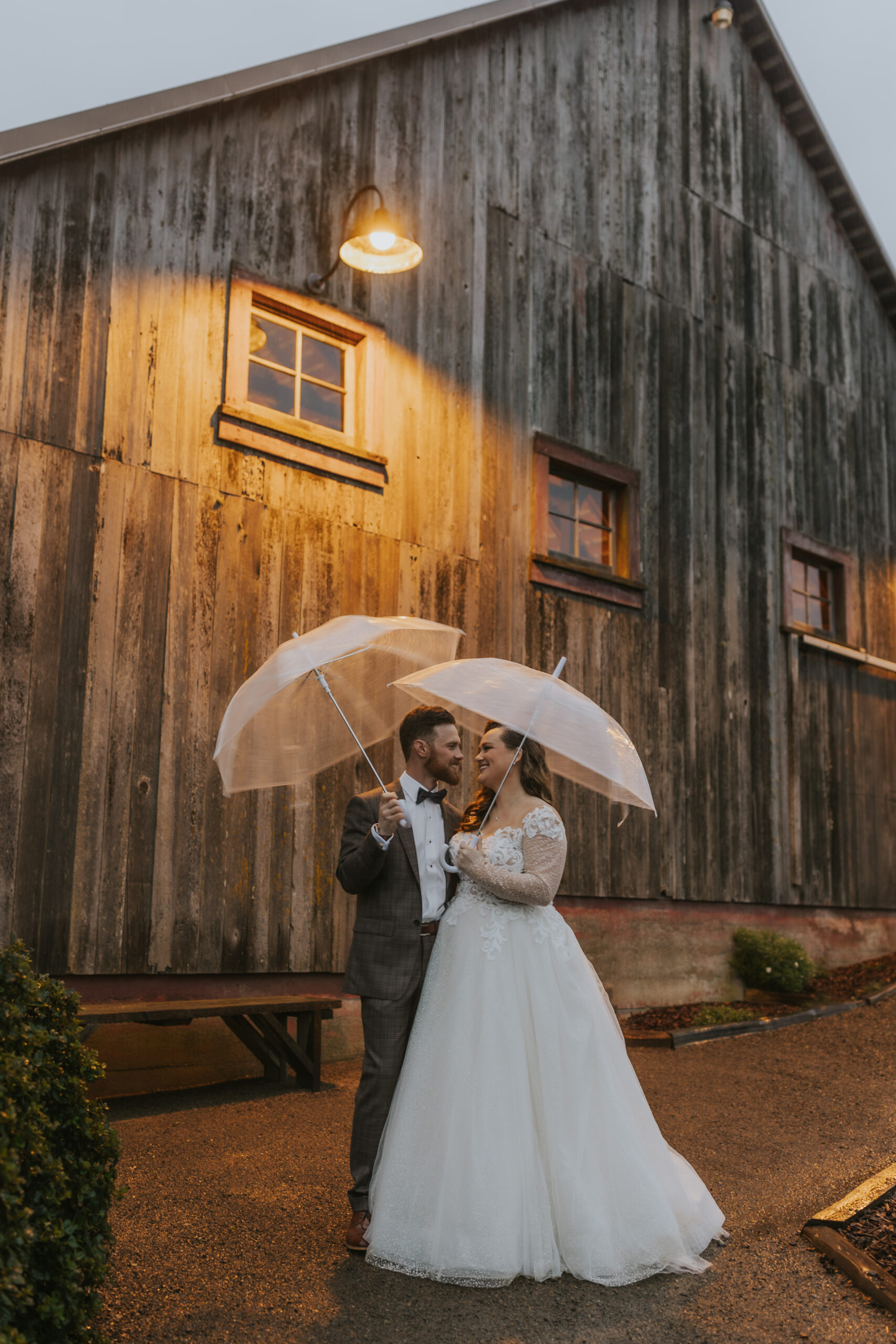 Bride and groom under umbrella during rainy wedding day at the Haven at Tomales