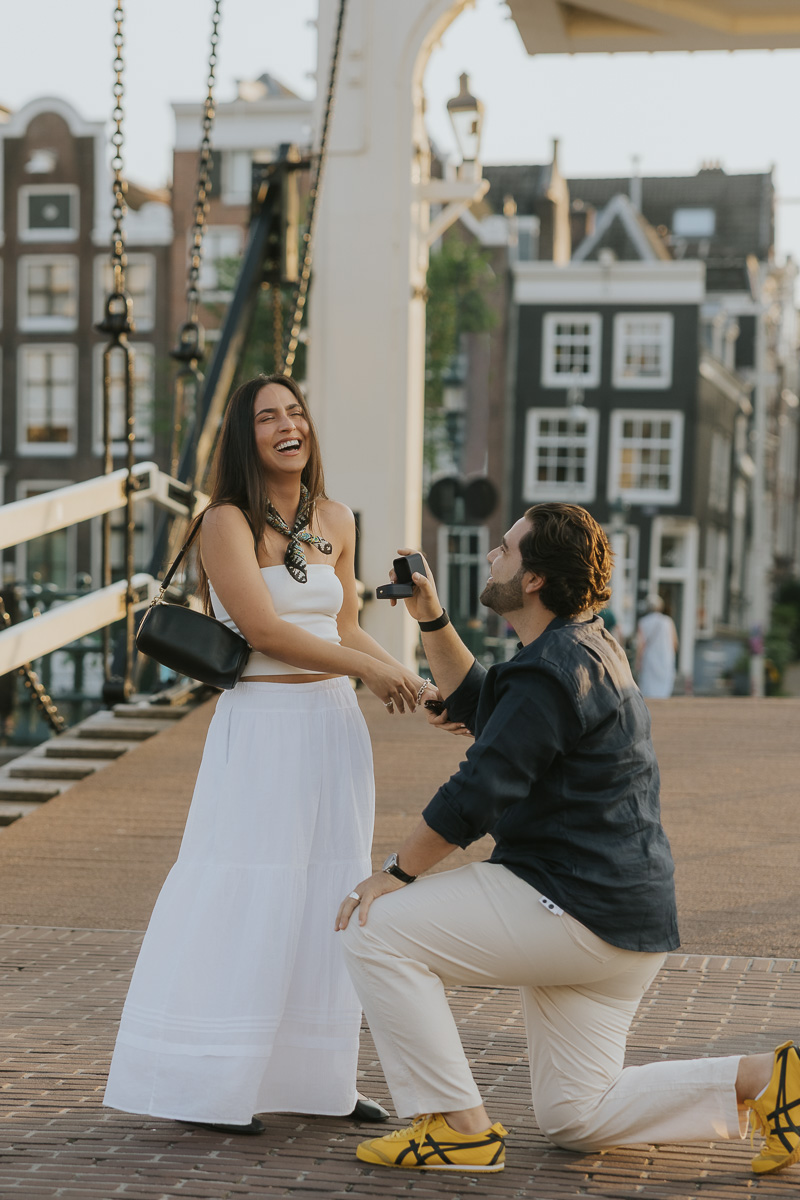 girl surprised by boyfriend surprise proposal on magere brug skinny bridge in amsterdam